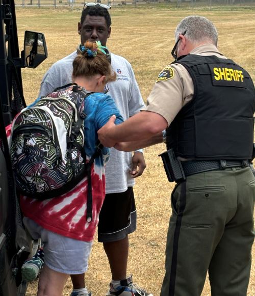 A volunteer with the Sheriff helping a fair attendee